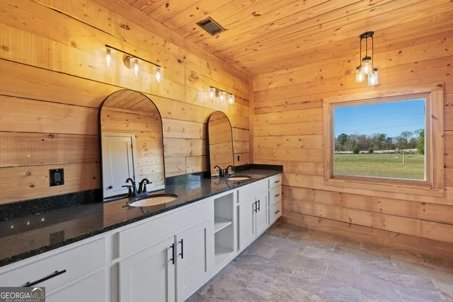 a bathroom with a double vanity sink and a large mirror