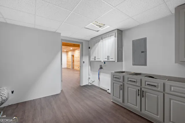 a view of a kitchen with wooden floors and white cabinets