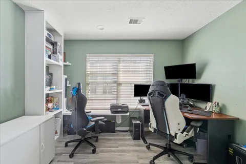 a view of a workspace with furniture and a window