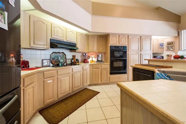 a kitchen with stainless steel appliances granite countertop a sink and a refrigerator