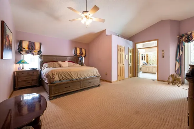 a spacious bedroom with a bed and a chandelier