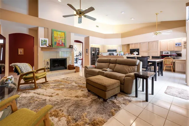 a living room with furniture a flat screen tv and kitchen view