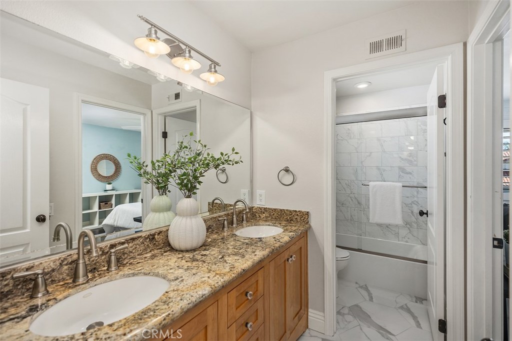 6 Calella Laguna Niguel, CA 92677 - Photo 23 of 28 a bathroom with a granite countertop sink a large mirror and shower