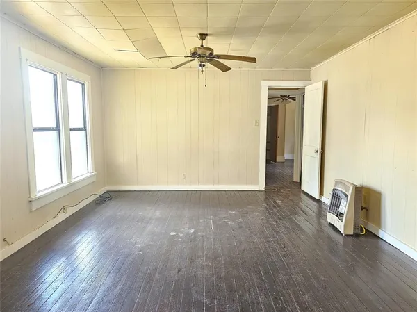 a view of a room with wooden floor and a ceiling fan