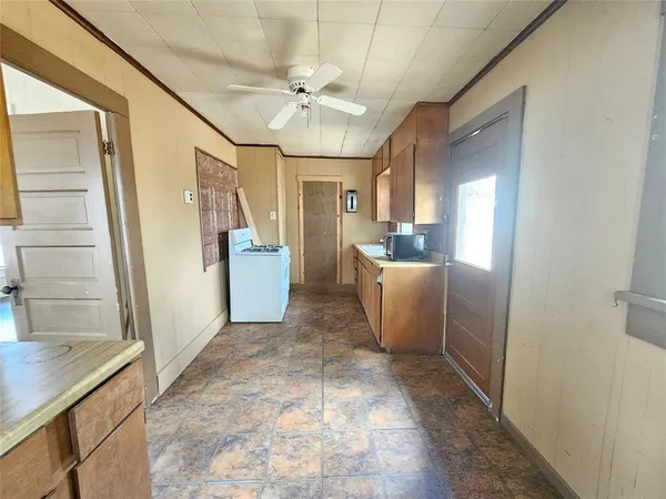 a view of a hallway to a livingroom with furniture stairs and wooden floor