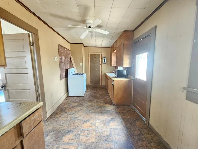 a view of a hallway to a livingroom with furniture stairs and wooden floor