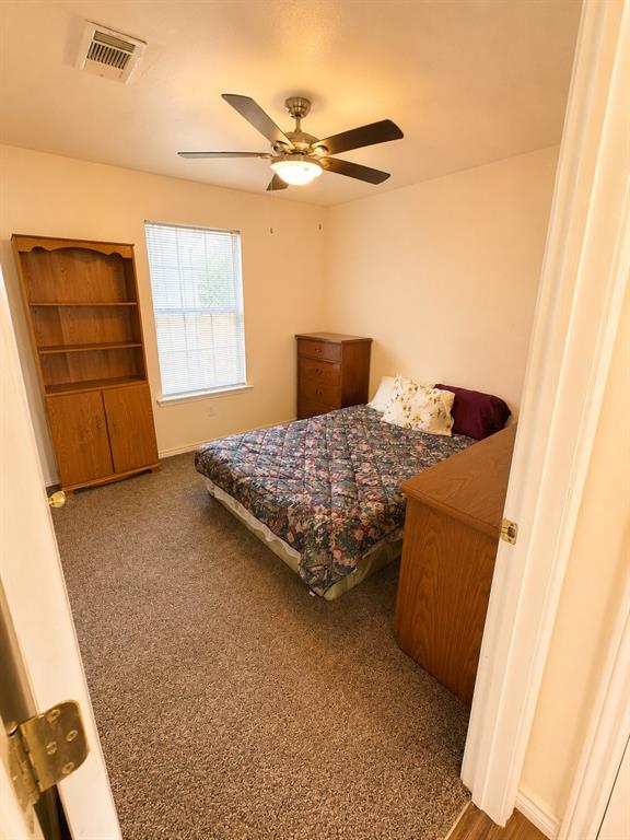 414 Tobe Street Gilmer, TX 75644 - Photo 9 of 9 Carpeted room featuring a ceiling fan with integrated lighting, a window with blinds, and light-toned walls
