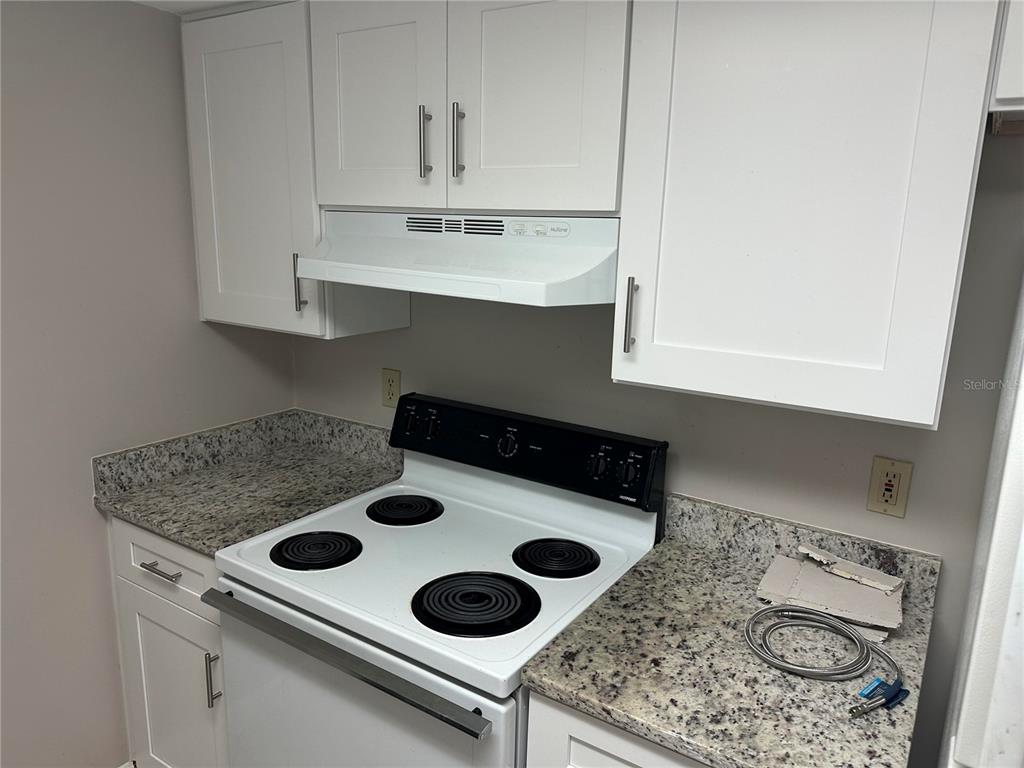904 Lake Destiny Road, Unit G Altamonte Springs, FL 32714 - Photo 6 of 22 a kitchen with a stove and a white cabinets