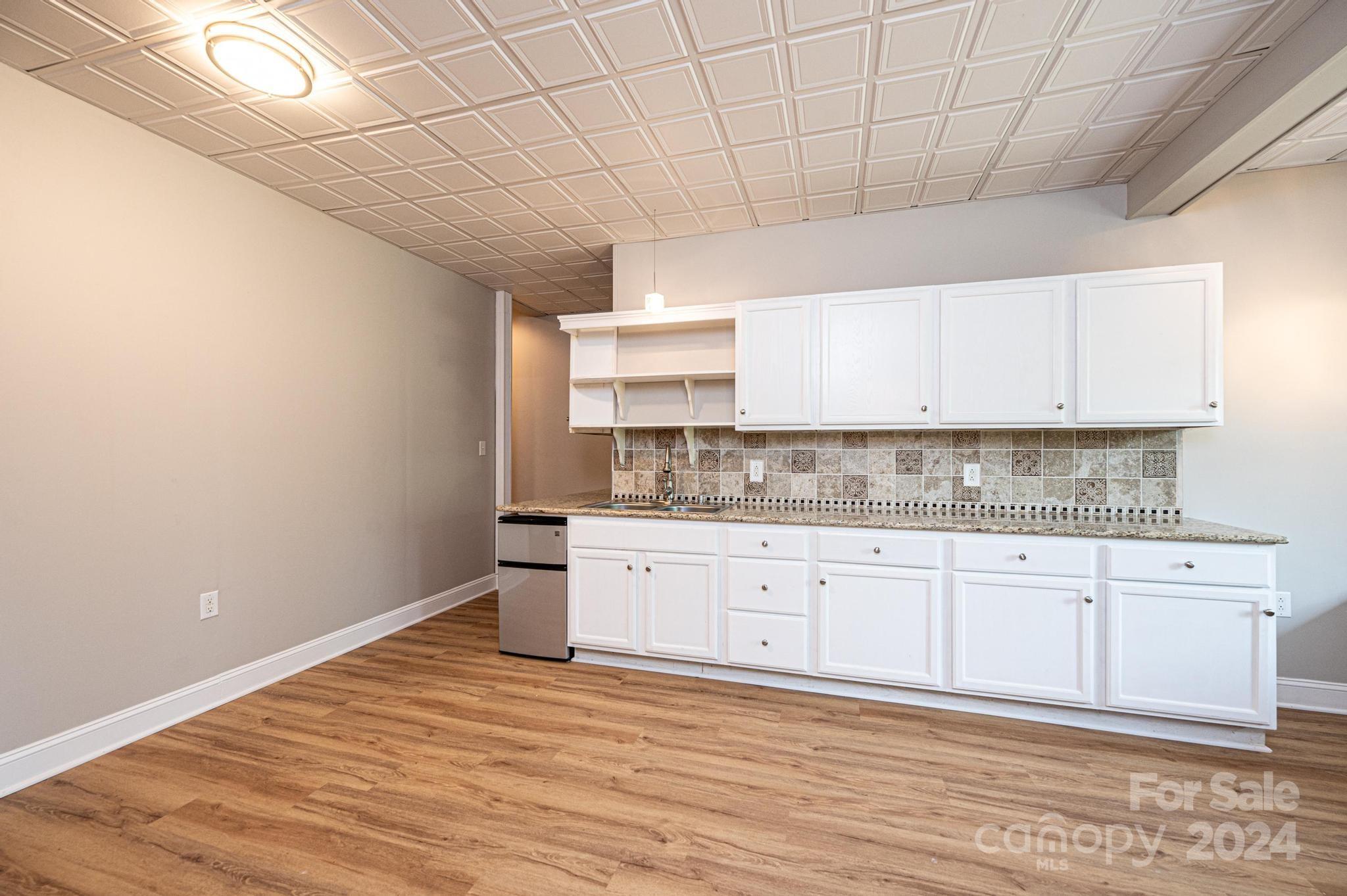 5366 Beacon Ridge Drive Granite Falls, NC 28630 - Photo 35 of 47 a kitchen with granite countertop white cabinets and a wooden floor
