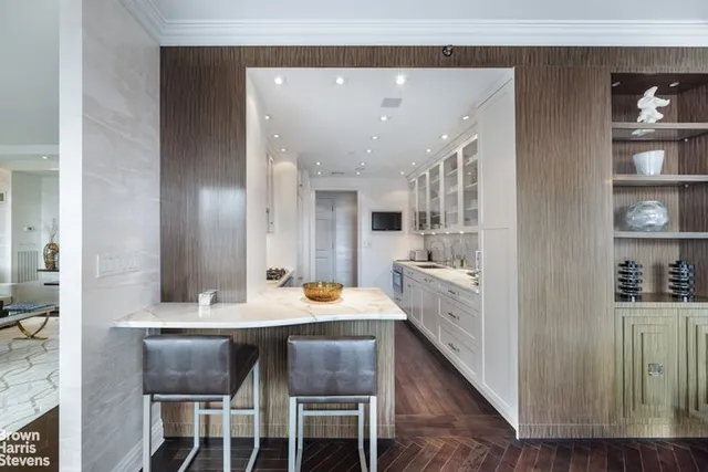 a large white kitchen with a large window a sink and stainless steel appliances