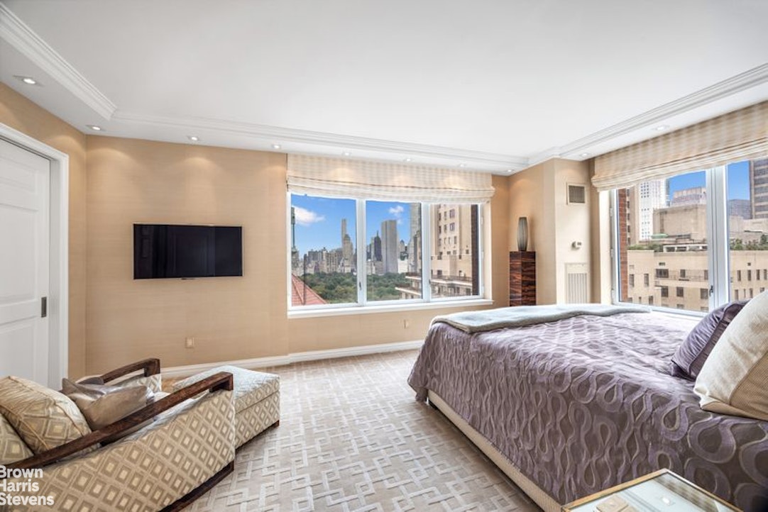 15 West 63rd Street, Unit 20B Manhattan, NY 10023 - Photo 8 of 14 a spacious bedroom with a bed and glass window