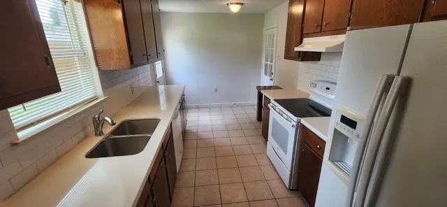 a kitchen with a sink a refrigerator and washer