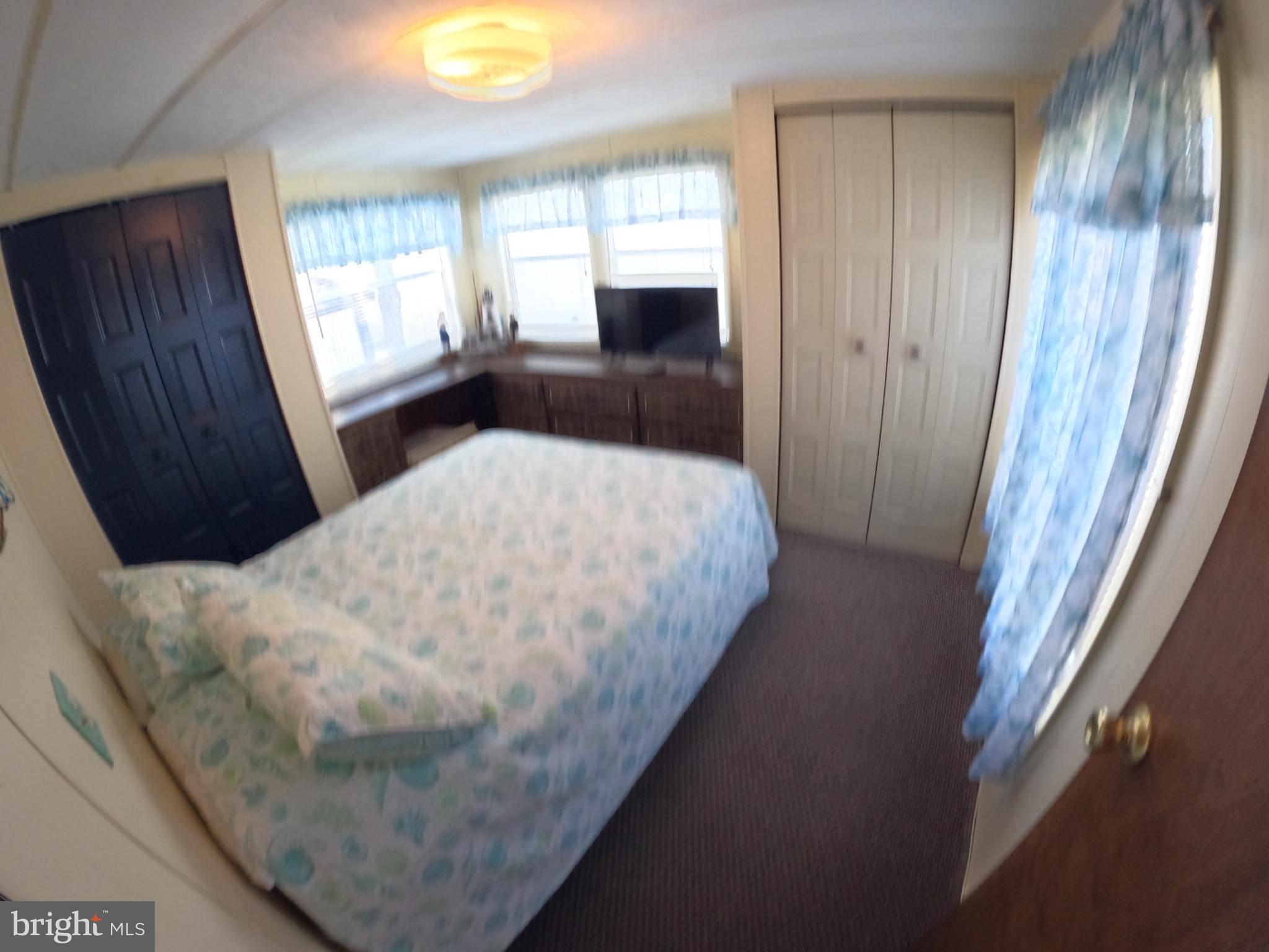 163 Clamshell Road Ocean City, MD 21842 - Photo 8 of 18 a bed sitting in a bedroom next to a window