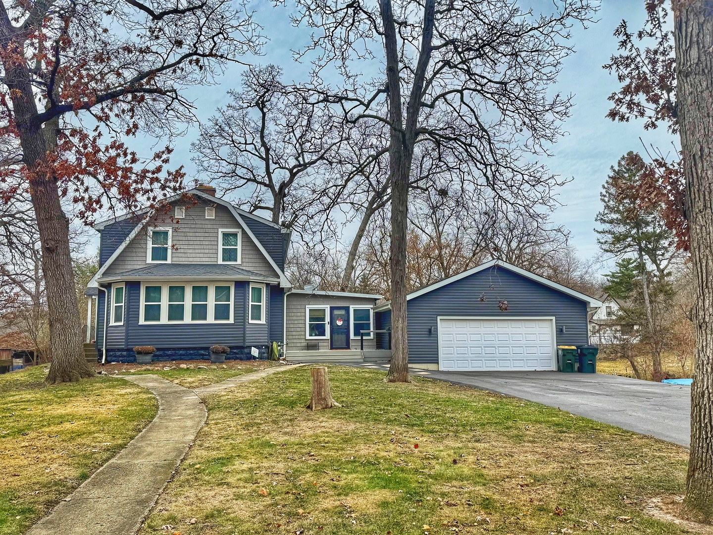 a front view of a house with a yard and trees