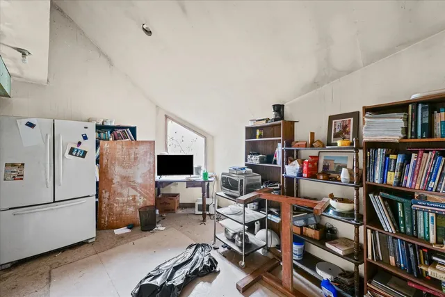 a view of a livingroom with workspace and a bookshelf