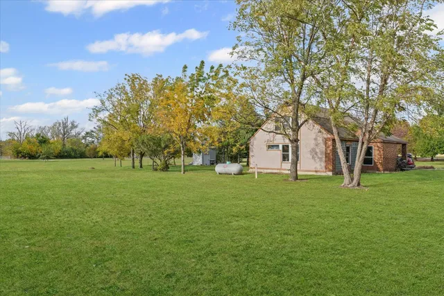 a huge green field with lots of trees in the background