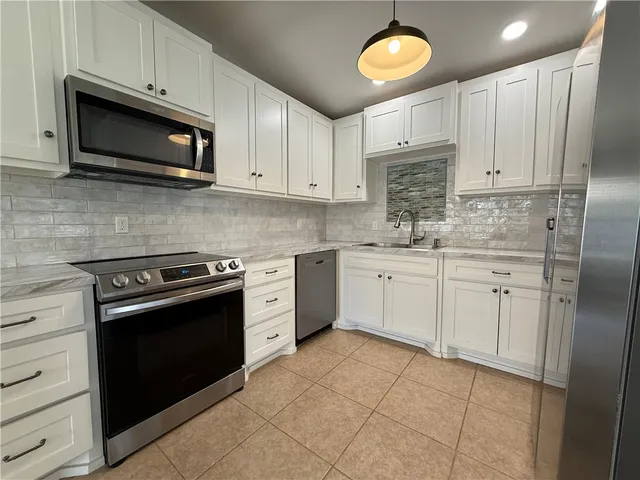 a kitchen with stainless steel appliances granite countertop a stove a sink dishwasher and a microwave