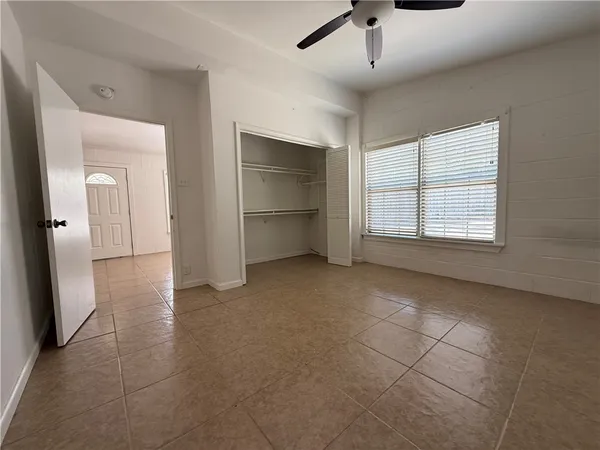 a view of empty room with window and refrigerator
