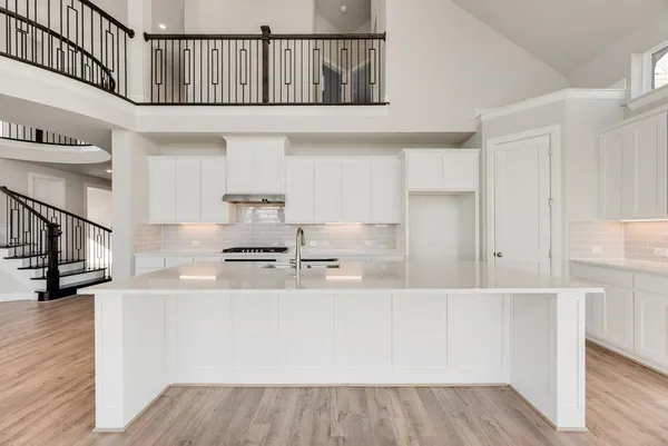 a kitchen with stainless steel appliances a refrigerator and white cabinets