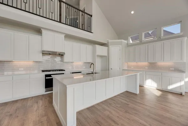 a kitchen with stainless steel appliances a white stove top oven and white cabinets