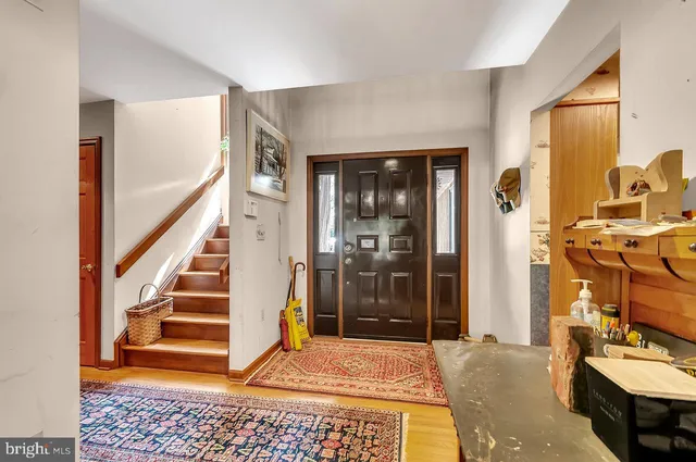 a living room with furniture large windows and wooden floor