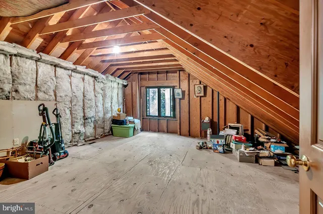 a view of a barn with wooden wall next to a road