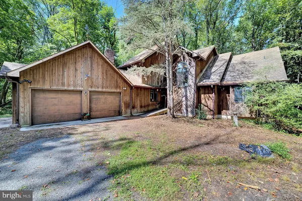 a front view of a house with a yard and trees