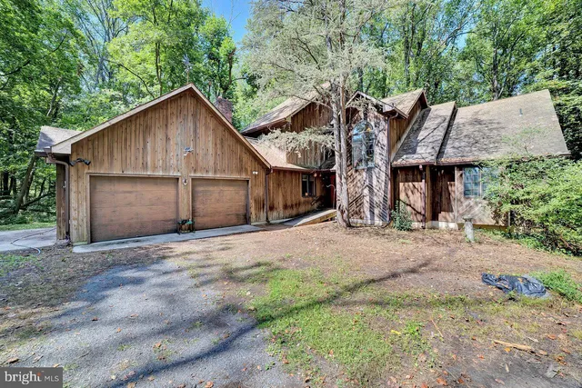 a front view of a house with a yard and trees