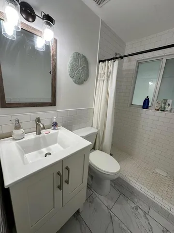 a bathroom with a sink toilet and shower