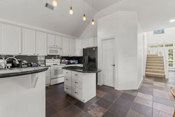 a kitchen with stainless steel appliances granite countertop a stove a sink and a refrigerator