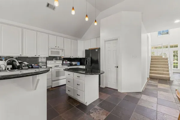 a kitchen with stainless steel appliances granite countertop a stove a sink and a refrigerator