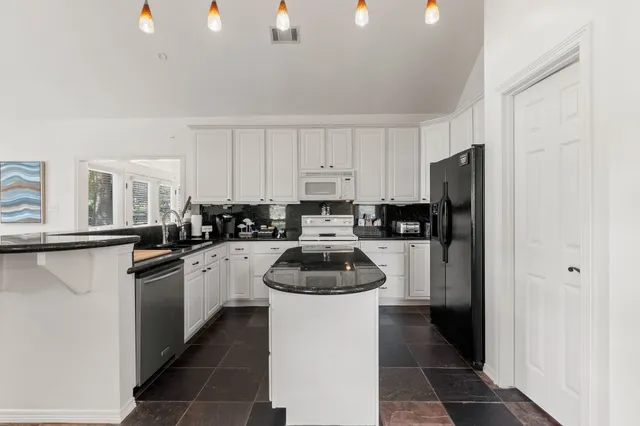 a kitchen with a refrigerator a stove a microwave and cabinets