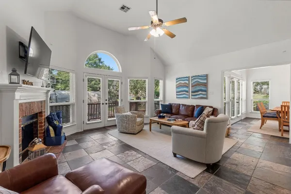 a living room with furniture a fireplace and a large window with garden view