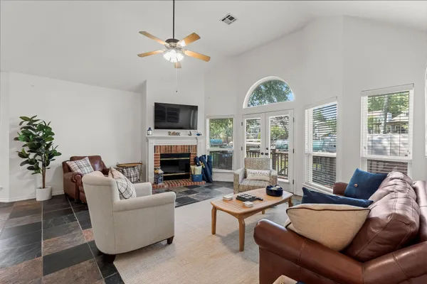 a living room with furniture a fireplace and a large window