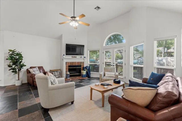 a living room with furniture a fireplace and a large window