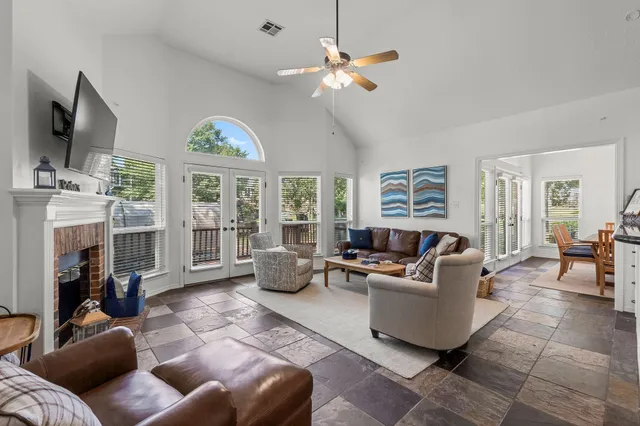 a living room with furniture a fireplace and a flat screen tv