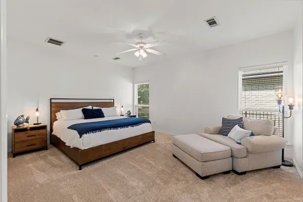 a spacious bedroom with a bed and a chandelier