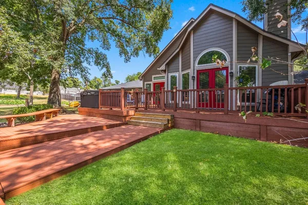 a view of an house with backyard and a tree