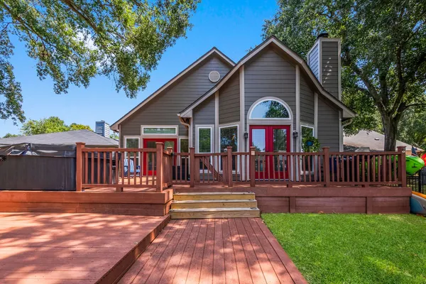 a front view of house with deck and yard