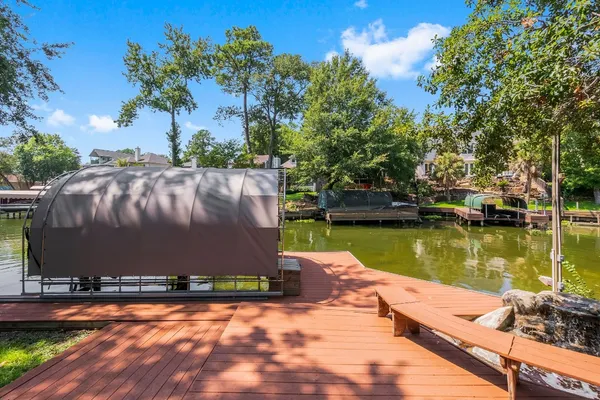 a view of a lake with a yard and a large tree