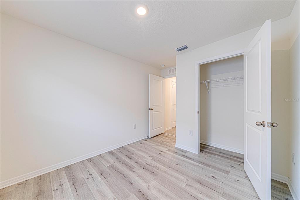 34026 Soaring Bamboo Path Wesley Chapel, FL 33543 - Photo 13 of 34 an empty room with wooden floor and a window