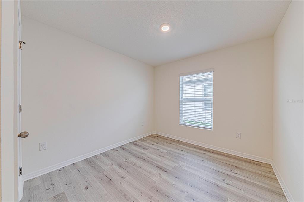 34026 Soaring Bamboo Path Wesley Chapel, FL 33543 - Photo 15 of 34 an empty room with wooden floor and windows