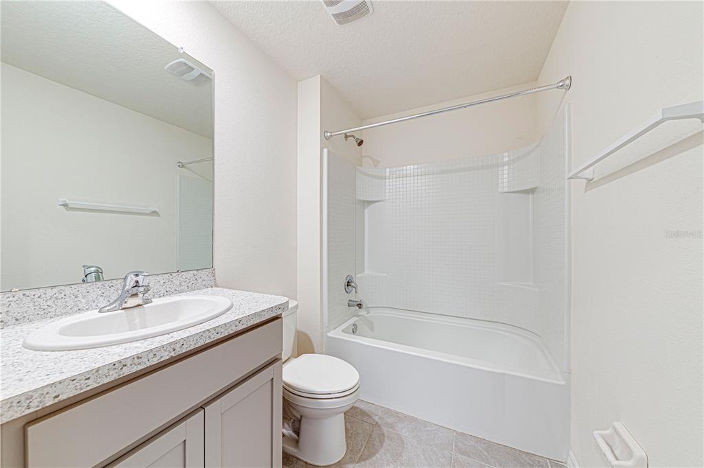 34026 Soaring Bamboo Path Wesley Chapel, FL 33543 - Photo 16 of 34 a bathroom with a granite countertop sink a toilet and shower