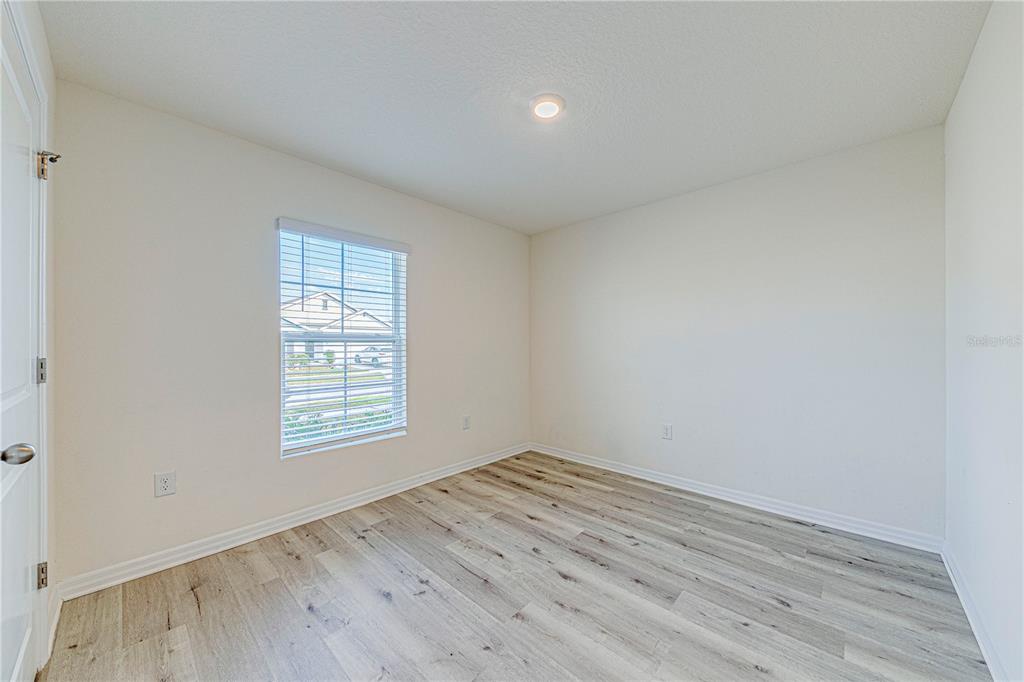34026 Soaring Bamboo Path Wesley Chapel, FL 33543 - Photo 24 of 34 an empty room with wooden floor and windows