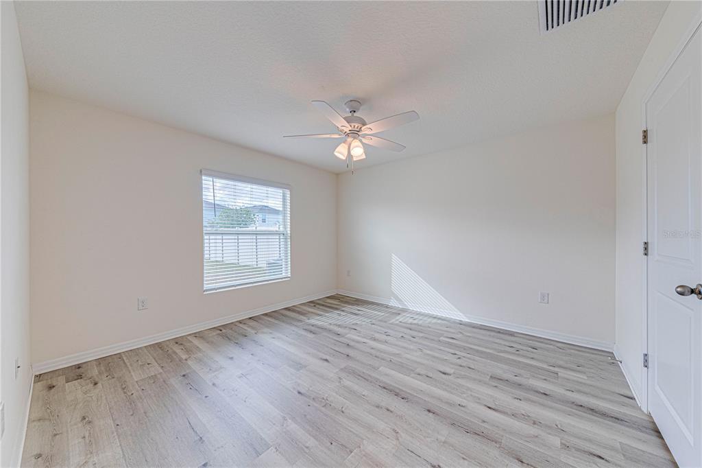34026 Soaring Bamboo Path Wesley Chapel, FL 33543 - Photo 26 of 34 wooden floor in an empty room with a window