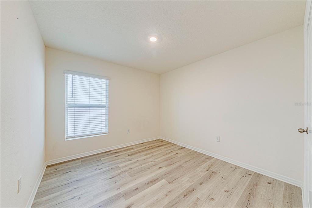 34026 Soaring Bamboo Path Wesley Chapel, FL 33543 - Photo 29 of 34 an empty room with wooden floor and windows