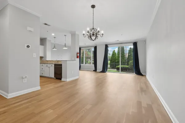 a view of an empty room with window and wooden floor