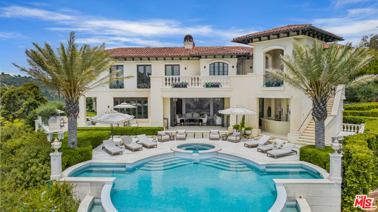 a view of a big house with fountain in a big yard