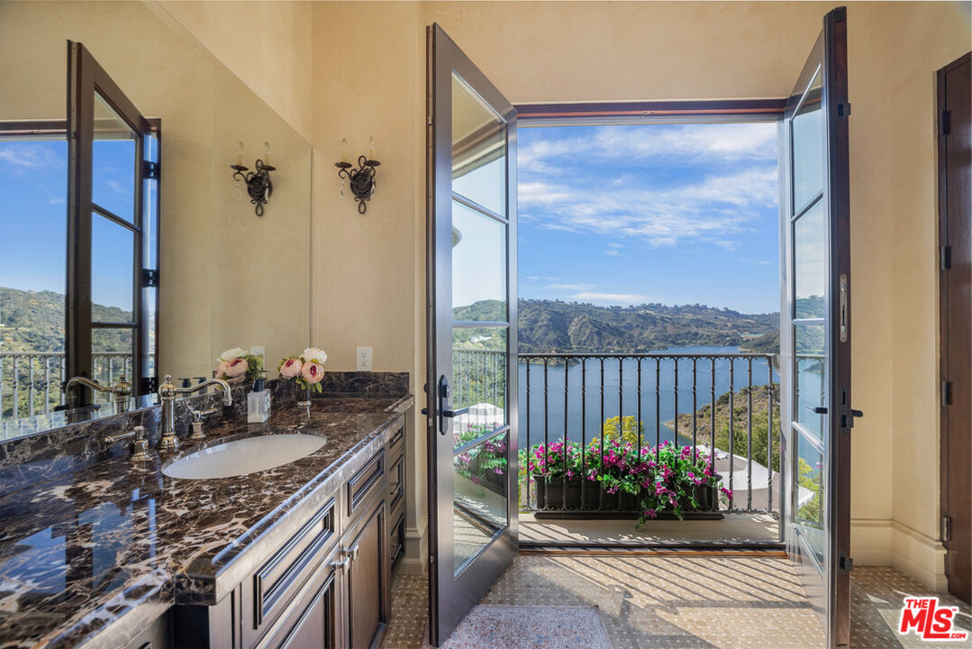 1940 Bel Air Road Los Angeles, CA 90077 - Photo 17 of 25 a bathroom with a granite countertop sink a mirror and shower
