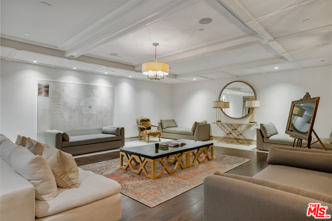1940 Bel Air Road Los Angeles, CA 90077 - Photo 19 of 25 a living room with furniture a mirror and a chandelier